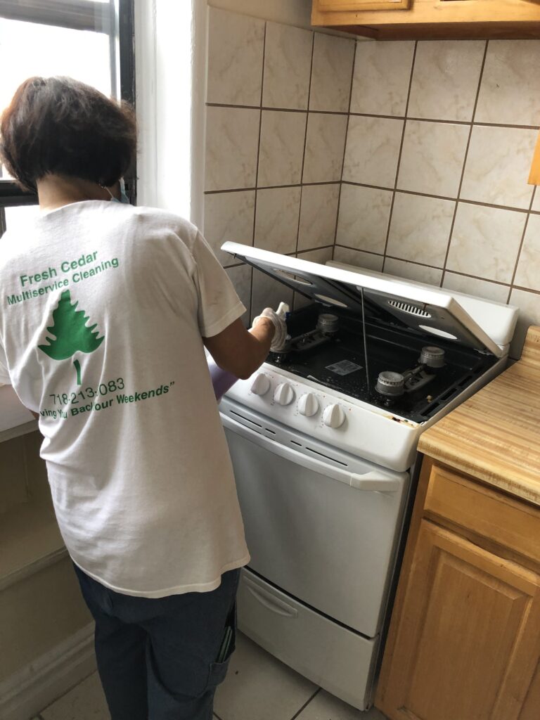 Women cleaning a washing machine while wearing a white shirt