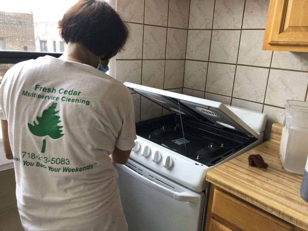 Women cleaning a machine while wearing a white shirt